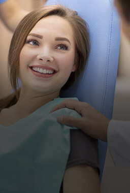 Smiling young woman in dental chair