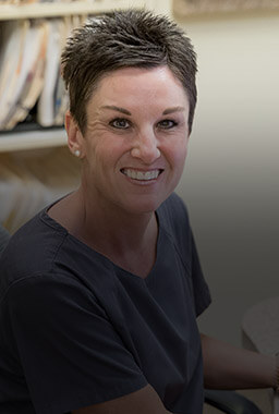 Office manager Kelly smiling at front desk