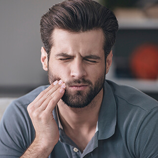 Man in pain holding cheek