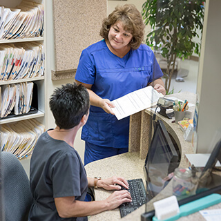 Two dental team members at front desk