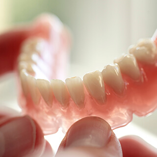 Hand holding a full denture