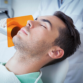 Man with eyes closed in dental chair